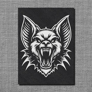 Peut inclure: Un rectangle noir avec une illustration blanche d'une créature ressemblant à un loup ou une chauve-souris qui grogne. Le dessin présente des dents pointues et de grandes oreilles, dans un style tatouage vintage.