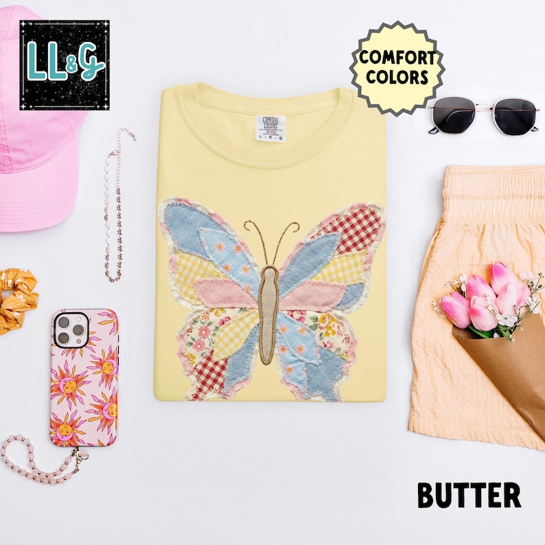 Peut inclure: Un sweat-shirt jaune clair avec un motif papillon patchwork en tissus bleus, roses et rouges. Le mot "BUTTER" est en bas &agrave; droite. Autres accessoires : lunettes de soleil, coque de t&eacute;l&eacute;phone rose et chapeau rose.