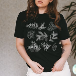 May include: A black t-shirt with a white design of pine branches and cones.
