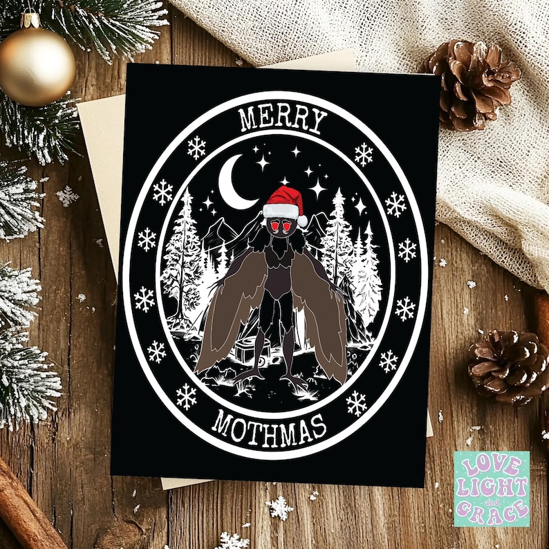 May include: A black and white Christmas card with a mothman wearing a Santa hat in a forest scene. The card says "Merry Mothmas".