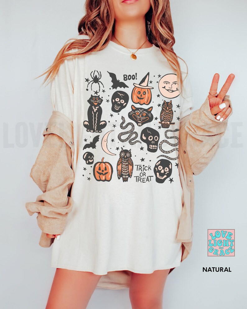 May include: A white t-shirt with a vintage Halloween design featuring black cats, owls, pumpkins, bats, skulls, snakes, and stars. The text "Boo!" and "Trick or Treat" are also included in the design.