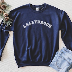 May include: Navy blue sweatshirt with white text that reads "LALLYBROCH" in an arched font.