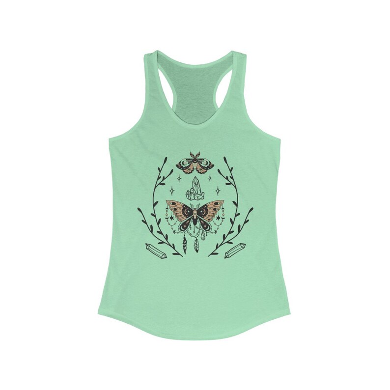 May include: A mint green tank top featuring a black and brown moth design. The moth is surrounded by a wreath of leaves and crystals.