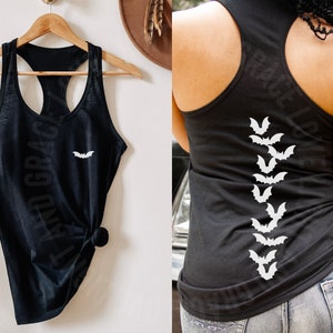May include: Black tank top with a white bat graphic on the front and a row of white bats down the back. The tank top is made of a soft, comfortable material.