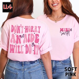 Peut inclure: T-shirt rose clair avec l'inscription "DON'T WORRY AN AIDE WILL DO IT" au dos et "MISS Smith" devant. Le motif comprend des papillons et des &eacute;toiles dans des tons de rose. Le t-shirt est &agrave; col rond.