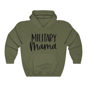 Pu&ograve; includere: Una felpa con cappuccio verde con la scritta "Military Mama" stampata in nero sul davanti.