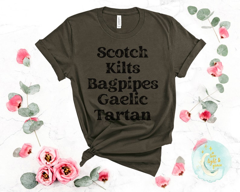 May include: A dark green t-shirt with the text "Scotch Kilts Bagpipes Gaelic Tartan" printed in black.
