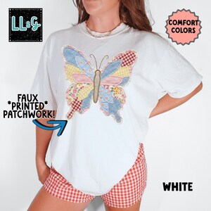 Peut inclure: T-shirt blanc avec un motif de papillon patchwork color&eacute;. Le papillon a des ailes &agrave; motifs bleus, roses, jaunes et rouges. Le t-shirt porte &eacute;galement les mentions "FAUX *PRINTED* PATCHWORK!" et "COMFORT COLORS".