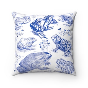 May include: Square throw pillow with a white background and a blue frog illustration. The design features various frog species in a detailed, vintage style, with botanical accents. The pillow is a decorative home accent.