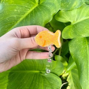 Pomarańczowa rolka z odznaką "Rybka Krakersa", Pomarańczowa rolka z brokatem, Rolka z odznaką pediatryczną dla pielęgniarki, Rolka z odznaką niestandardową, Spersonalizowana rolka z odznaką
