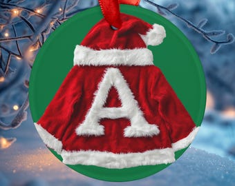 Könnte beinhalten: Ein roter und weißer Weihnachtsbaumschmuck in Form eines Weihnachtsmannkostüms mit dem Buchstaben "A" in Weiß auf der Vorderseite.
