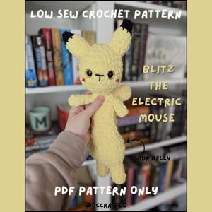May include: A handmade yellow crochet plushie of a cartoon mouse with black-tipped ears, black eyes, and a red blush. The text "BLITZ THE ELECTRIC MOUSE" is visible. The image also includes the text "LOW SEW CROCHET PATTERN" and "PDF PATTERN ONLY".