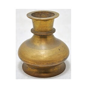 May include: A small, brass vase with a round body and a flared top. The vase has a smooth, polished finish and a slightly aged patina.