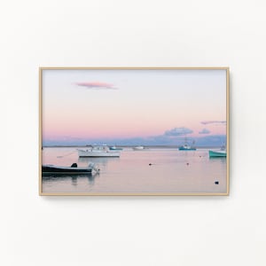 May include: A framed photograph of a seascape with a pink and purple sunset over calm water. Several boats are anchored in the water, with a few buoys visible.