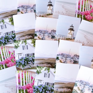 May include: A collection of photographs featuring coastal scenes, including a white lighthouse, a white house with blue shutters, and a harbor with sailboats. The photos are printed on white cardstock and arranged in a grid pattern.