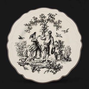 May include: A round ceramic plate with a scalloped edge featuring a black and white toile-style illustration of two figures dancing under a tree, surrounded by birds, plants, and foliage. The plate has a cream-colored base with a dark rim.