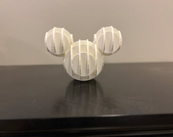 May include: White 3D printed sculpture of Mickey Mouse's head. The sculpture is made of multiple layers of circles that are stacked on top of each other.