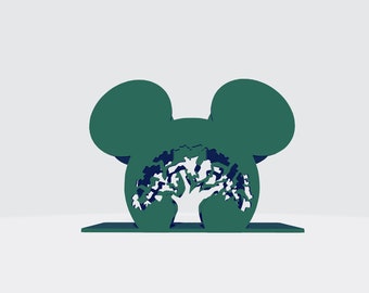 May include: A green, mouse-shaped, decorative object with a tree silhouette cut out in the center.