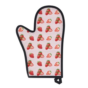 May include: A pink oven mitt with a black trim and a pattern of red strawberries.