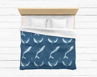 May include: A blue duvet cover with a white whale pattern. The whales are in a repeating pattern on a dark blue background.