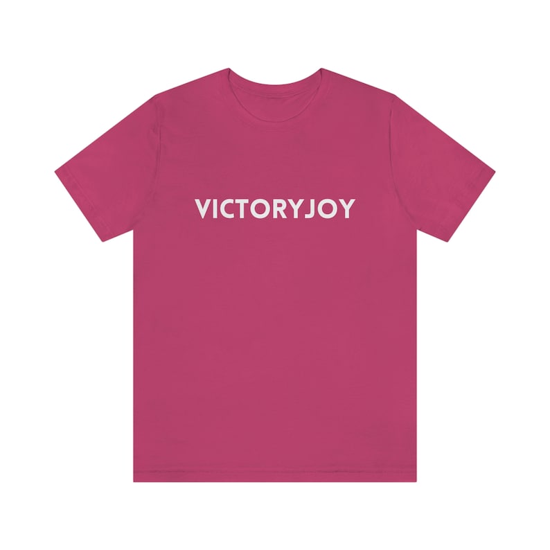 Puede incluir: Una camiseta rosa con el texto "VICTORYJOY" impreso en blanco en la parte delantera.
