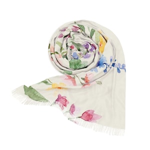 May include: Rolled ivory scarf with a watercolor floral pattern. The scarf features pink, purple, yellow, and blue flowers with green leaves. The edges have a fringed trim.