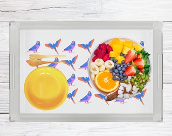 Puede incluir: Una bandeja de servir blanca con una ensalada de frutas colorida en un tazón blanco. La bandeja tiene un patrón de pájaros azules y morados sobre un fondo blanco. La ensalada de frutas incluye fresas, arándanos, mango, kiwi, plátanos y rodajas de naranja.