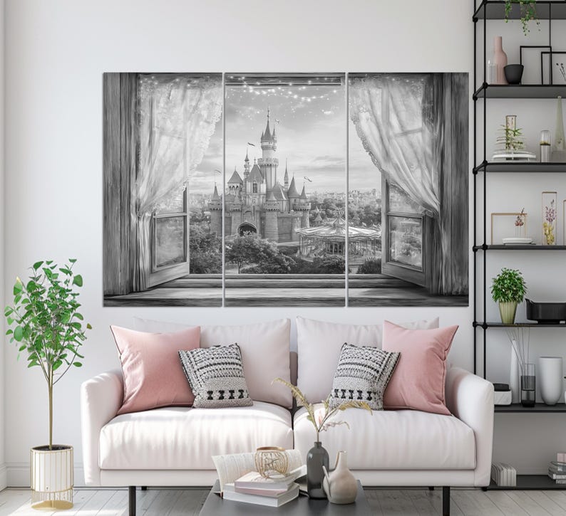 May include: Black and white canvas art set depicting a castle scene viewed through an open window with sheer curtains. The artwork is displayed above a white sofa with pink and patterned pillows. A small plant and decorative items are on a nearby table.