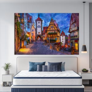 May include: A digital painting depicting a charming European town at dusk. The buildings are brightly coloured and have a medieval style. The street is cobbled and there are people walking around. The sky is a deep blue with clouds.