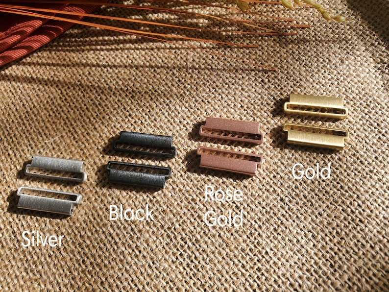 Pu&ograve; includere: Quattro paia di connettori per cinturino da orologio in metallo color argento, nero, oro rosa e oro.