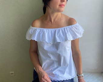 Blusa de algodón blanca estilo vintage, hombros descubiertos con encaje y mangas abullonadas.