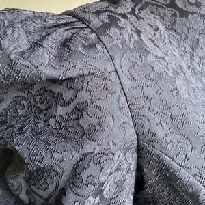 May include: Black dress with a floral pattern and puffed sleeves.