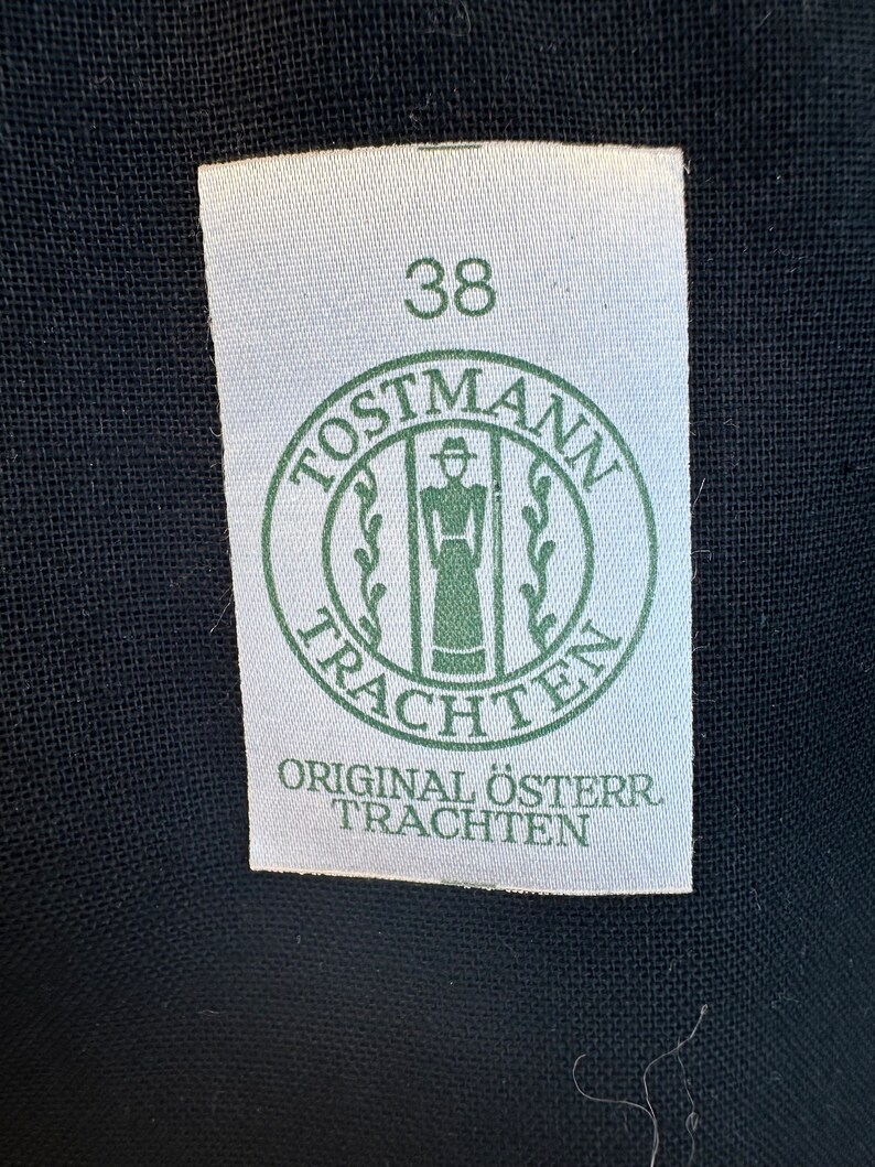 May include: A white tag with a green circle logo that says "Postmann Trachten" and the number 38. The tag also says "Original &Ouml;ster. Trachten".