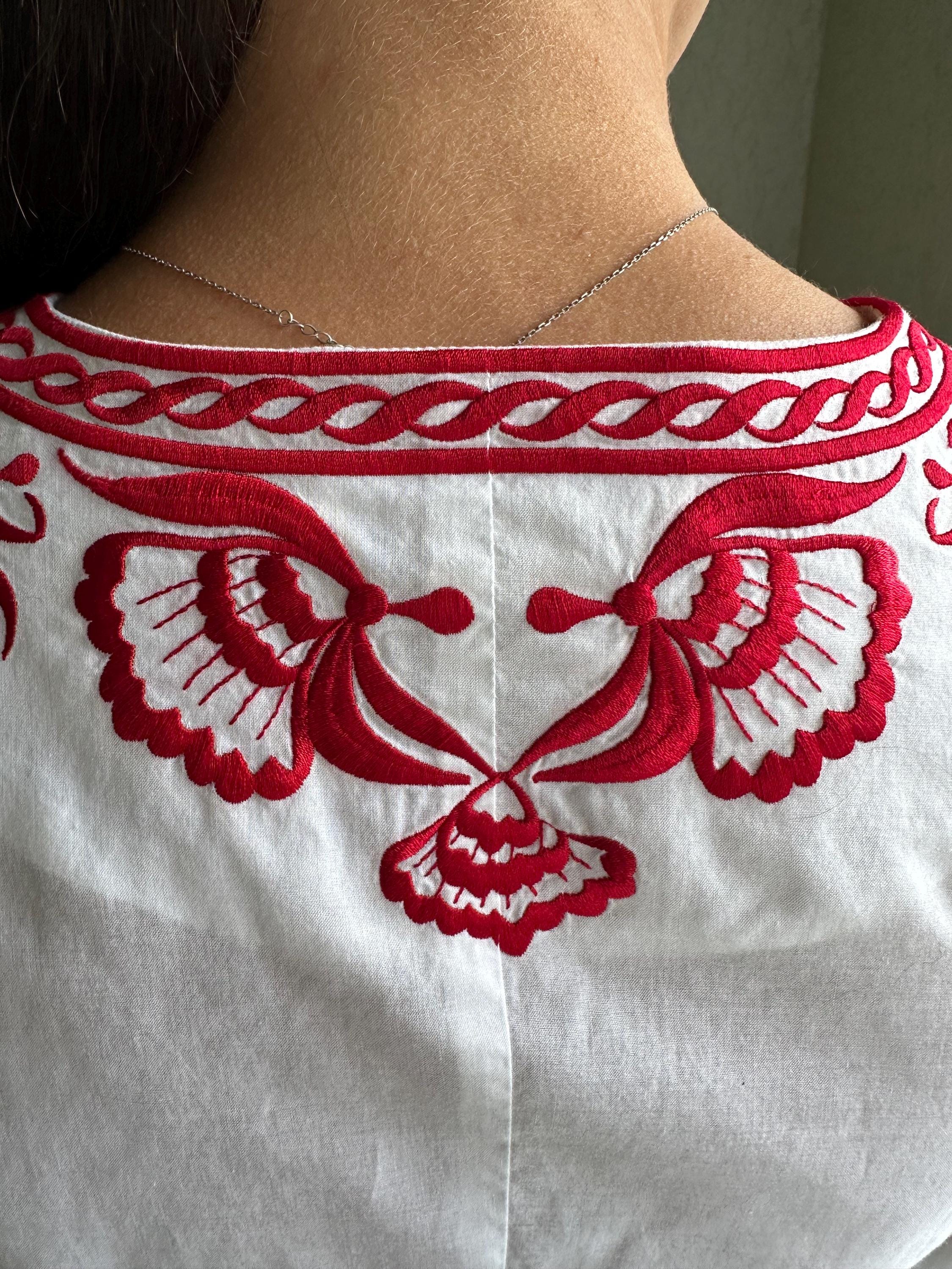 ホワイトのノースリーブ刺繍ブラウス、赤い花の刺繍が施された 