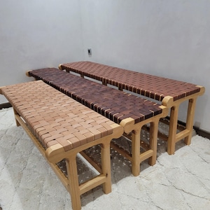 Peut inclure: Trois bancs en bois avec des assises tiss&eacute;es de diff&eacute;rentes nuances de marron. Les bancs ont des pieds et des cadres en bois de couleur claire. Les si&egrave;ges sont faits de lani&egrave;res de bois tiss&eacute;es, cr&eacute;ant une surface textur&eacute;e. Les bancs sont dispos&eacute;s en rang&eacute;e.