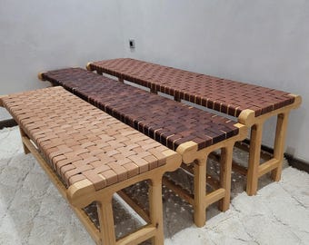 May include: Three wooden benches with woven seat tops in varying shades of brown. The benches have light-colored wooden legs and frames. The seats are made of woven strips of wood, creating a textured surface. The benches are arranged in a row.