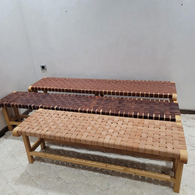Peut inclure: Trois bancs en bois avec des assises tress&eacute;es. Les bancs ont un cadre en bois naturel et les assises sont faites de lani&egrave;res de bois tress&eacute;es dans des tons marron clair, marron moyen et marron fonc&eacute;. Les bancs sont de longueurs variables.