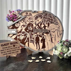Könnte beinhalten: Holzrahmen für ein Star Wars-Gästebuch mit lasergeschnittenen Figuren, darunter Darth Vader und Yoda. Der Rahmen hat einen silbernen Rand und ein Schild mit der Aufschrift "Guest Book". Das Datum "October 21st, 2023" ist ebenfalls sichtbar.