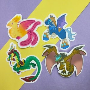 May include: Four colorful stickers featuring mythical creatures. A pink and yellow phoenix, a green dragon, a blue winged horse, and a brown dragon with wings.