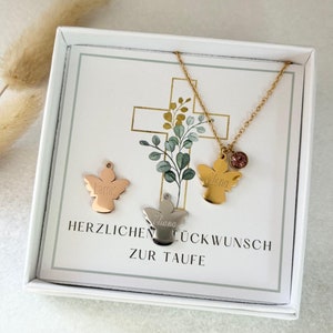 May include: A white box with a card inside. The card has a cross with green leaves and two angel pendants with the names "Elena" and "Liana" on them. The card also says "Herzlichen Gl&uuml;ckwunsch zur Taufe".
