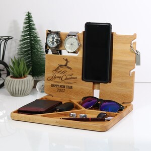 May include: Wooden organizer with compartments for a phone, watch, sunglasses, keys, and other small items. It has a reindeer design and the text "Merry Christmas Happy New Year 2022".