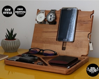 May include: Wooden organiser with compartments for a phone, watch, glasses, and other small items. The organiser is made of light brown wood and has a natural finish.