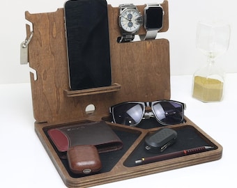 May include: A wooden organizer with multiple compartments for holding everyday essentials. It features slots for a phone, watch, sunglasses, and a wallet. There is also a small compartment for keys and a pen holder.