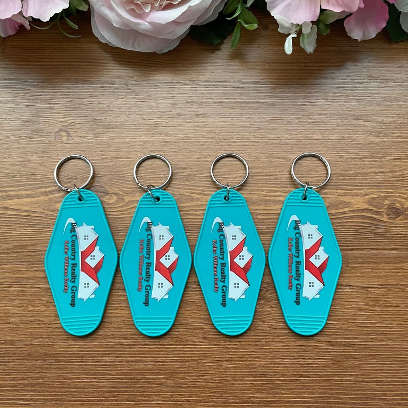 May include: Four turquoise blue keychains with a white and red logo that says "Big Country Realty Group" and "Keller Williams Realty".