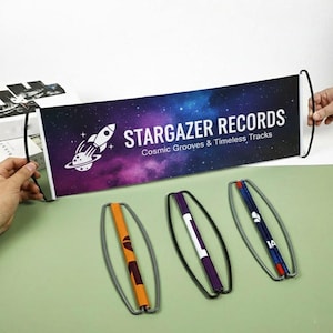 May include: A banner with the text "STARGAZER RECORDS" and a rocket ship graphic against a purple and blue galaxy background. Below are three colorful, oval-shaped exercise bands.