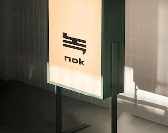 May include: A green illuminated sign with a black logo and the word "nok" in white text.