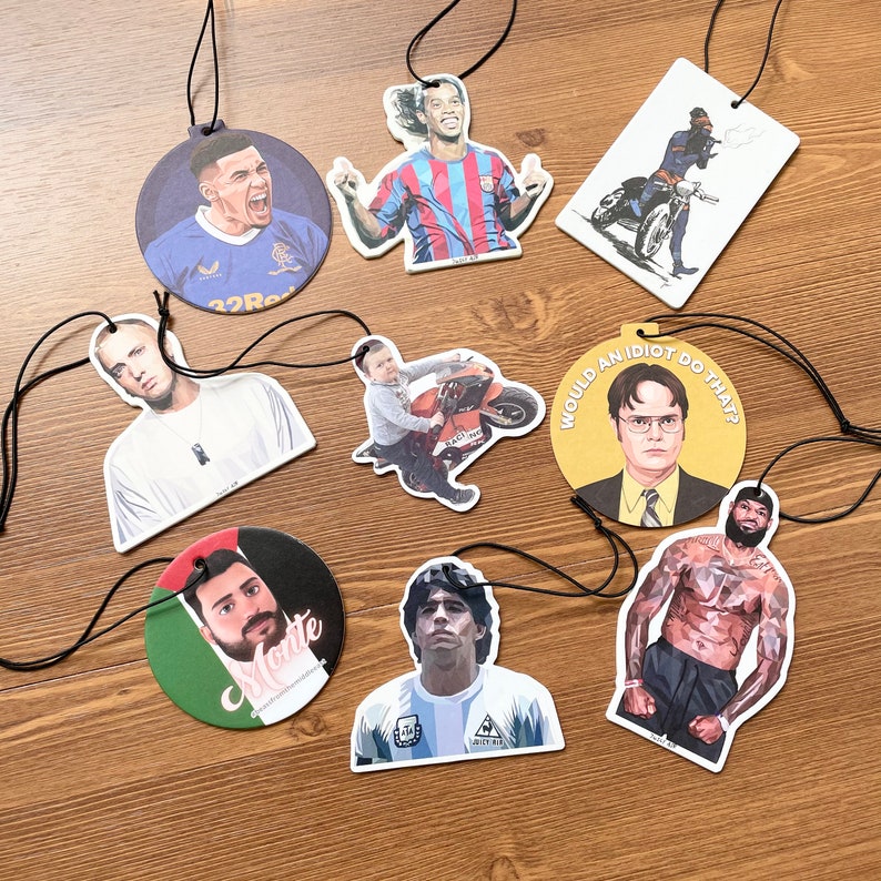 May include: Ten different car air fresheners with various designs. Some feature sports figures, others feature funny sayings, and one features a muscular man.