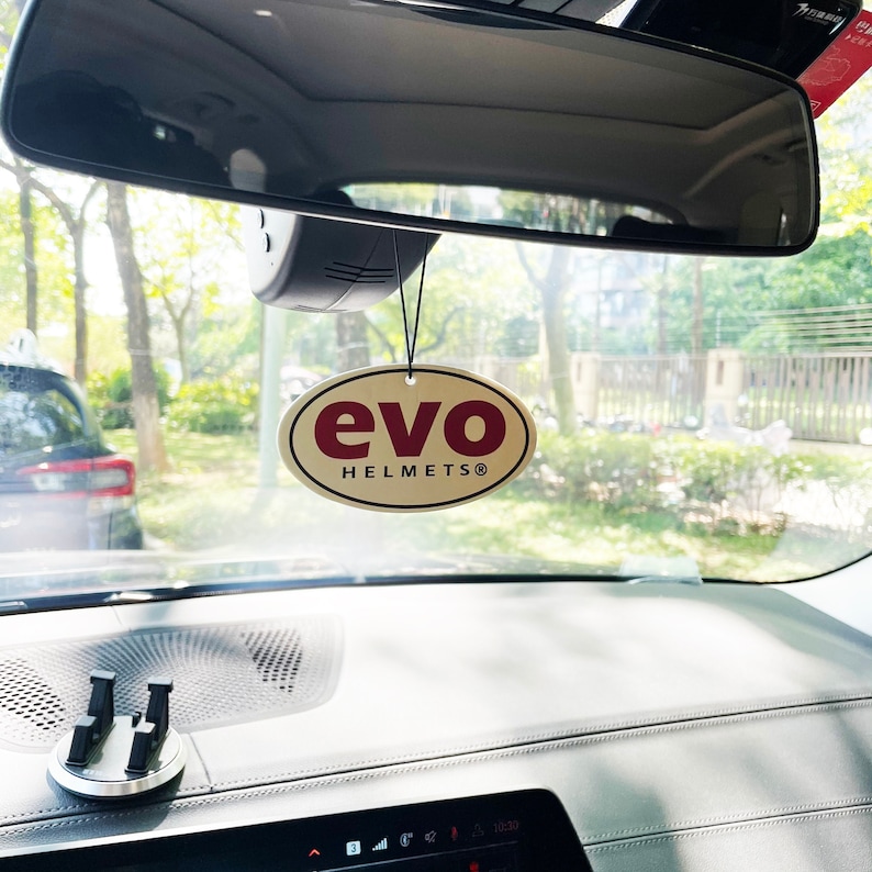 May include: A gold oval car air freshener with the text "evo HELMETS&reg;" in red lettering.