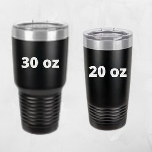May include: Two black insulated tumblers with silver rims and lids. The larger tumbler is labeled "30 oz" and the smaller one is labeled "20 oz". Both tumblers have a textured lower body.