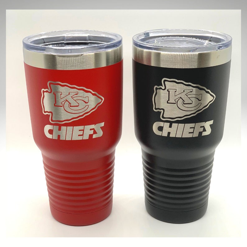 Op de afbeelding: Twee roestvrijstalen bekers, een zwarte en een rode. Beide bekers hebben een zilveren gegraveerd logo van de Kansas City Chiefs met de teamnaam eronder.